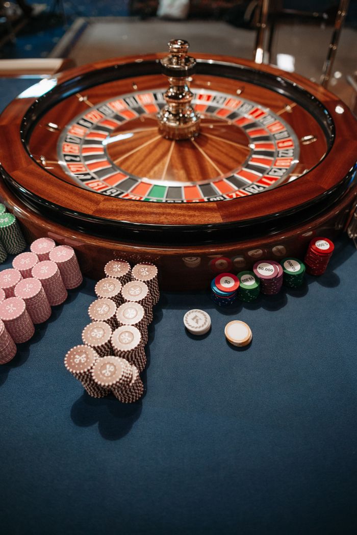 Services Roulette wheel on table with neatly stacked poker chips, capturing the essence of a casino.